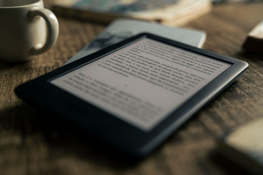 A tablet displaying an ebook on a wooden table next to a coffee cup, ideal for tech and lifestyle themes.